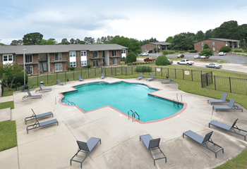 An aerial view of a swimming pool with chairs around it